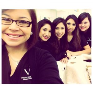 Five smiling women wearing Vogue College shirts